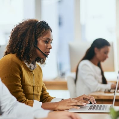 person with headset on working at laptop