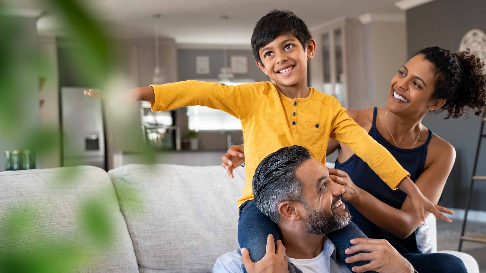 smiling_boy_on_dads_shoulders_with_mom